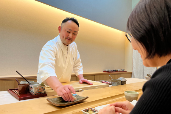 A traditional Japanese sushi counter in Fukuoka with fresh nigiri prepared by a professional chef